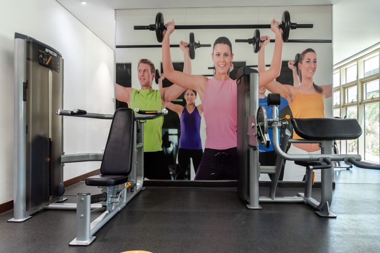 A gym with exercise equipment and a large mirror.