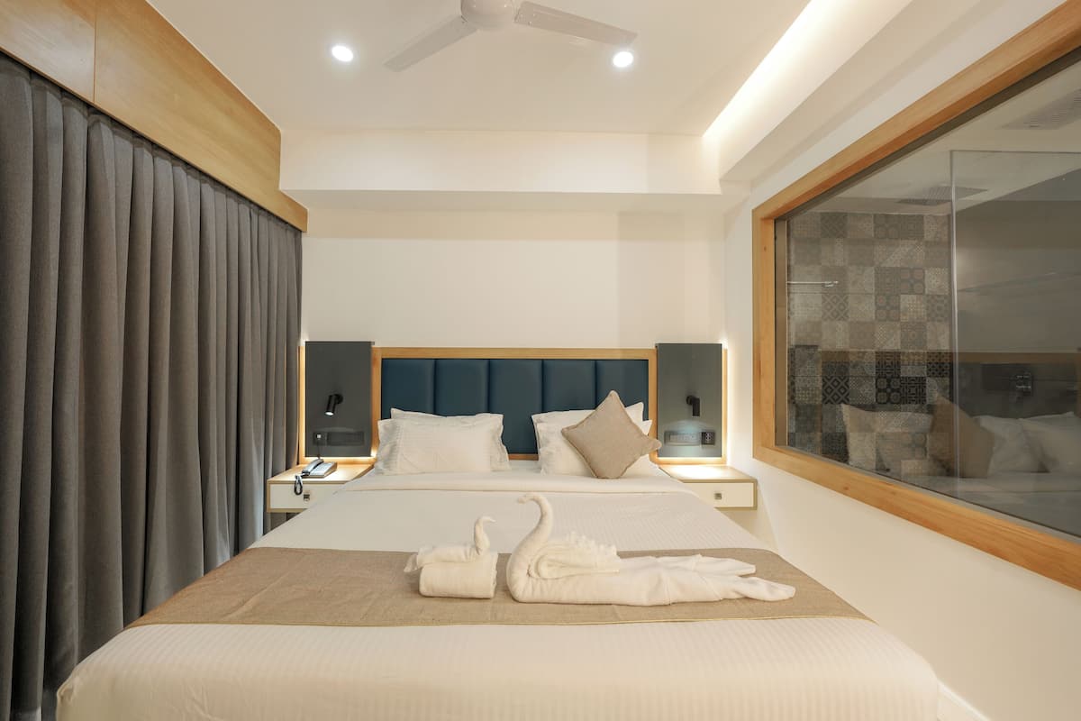 Une chambre d’hôtel moderne avec un grand lit, une douche à l’italienne et vue sur la salle de bain.