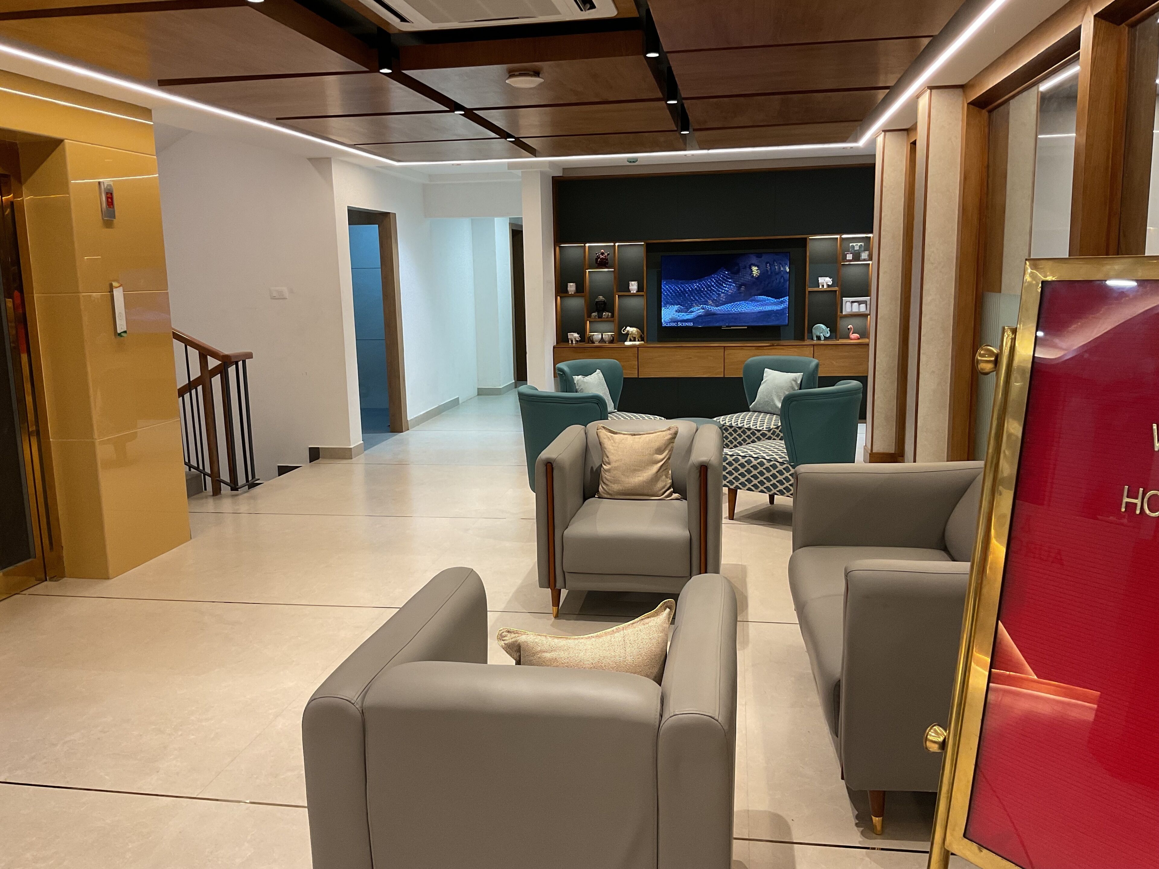 Una sala de estar moderna con sofás grises y un televisor al fondo.