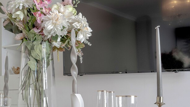 A dining table set with glassware, a white bowl, and a vase with flowers. - Iconic Oxford Street Apartment ✨ 2 Bed 1 Bath ✨ Tube ✨ Bond Street 📍 (Greater London)