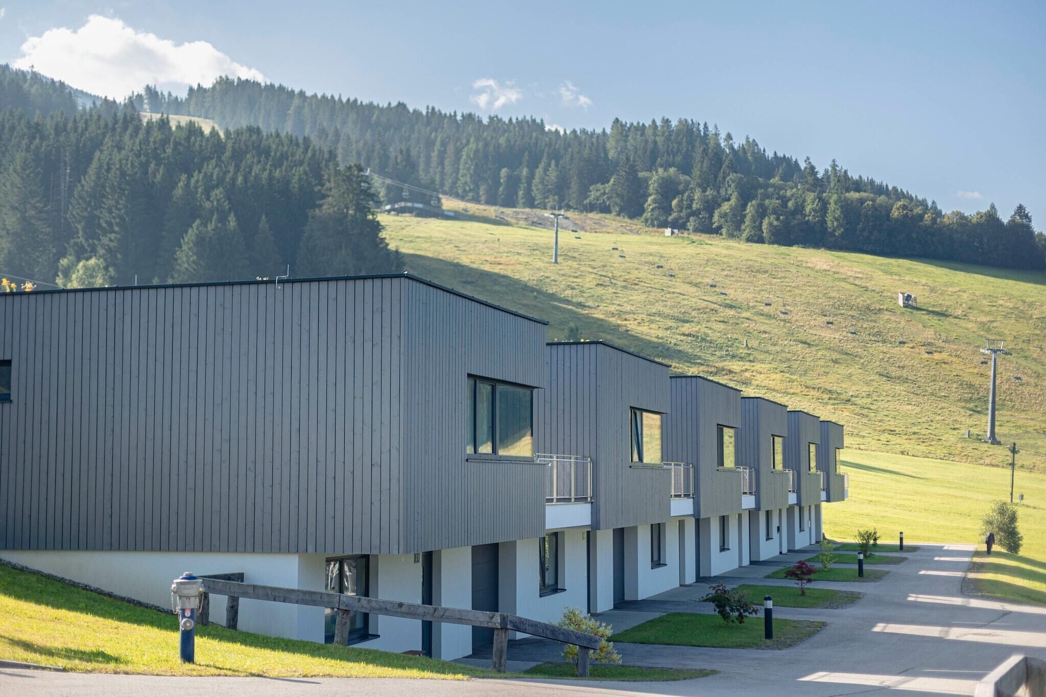 A modern building with a flat roof and a series of balconies.