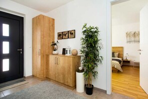 Enter a serene bedroom with a black door, wardrobe, and potted plant.