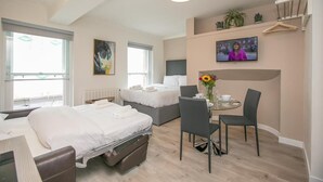 A hotel room with two beds, a desk with a chair, a TV, and a window. - St Stephen's Green District-1 (Dublin)