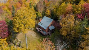 A cabin surrounded by autumn foliage.