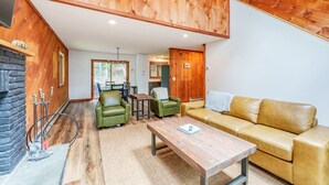 A wooden interior with a sofa, chairs, and a coffee table.