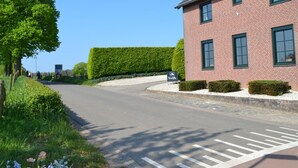 A red brick building with a green hedge and a clear blue sky. - Attractive Farmhouse in South Limburg With Terrace (Klimmen)