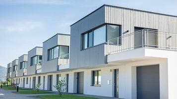 Un hôtel moderne à plusieurs étages, doté d’un toit plat, de grandes fenêtres et d’un espace extérieur couvert agrémenté d’une rambarde en métal.