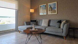 A modern living room with a grey sofa, a round coffee table, and two framed pictures on the wall. - w*| Comfy 2BR w/ Park View  in Miraflores (Lima)