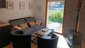 Una sala de estar moderna con sofá, sillas, una mesa de centro, chimenea y cuadros en la pared.