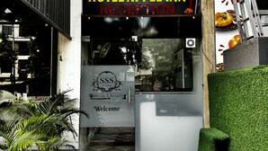 The entrance to Hotel Apple Inn Reception with a checkered floor pattern, a red carpet, and a sign for the hotel group. - Hotel Apple INN (Indore)