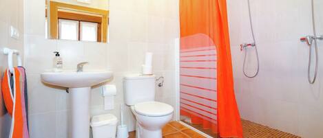 Ein Badezimmer mit Waschbecken, Toilette und Dusche.