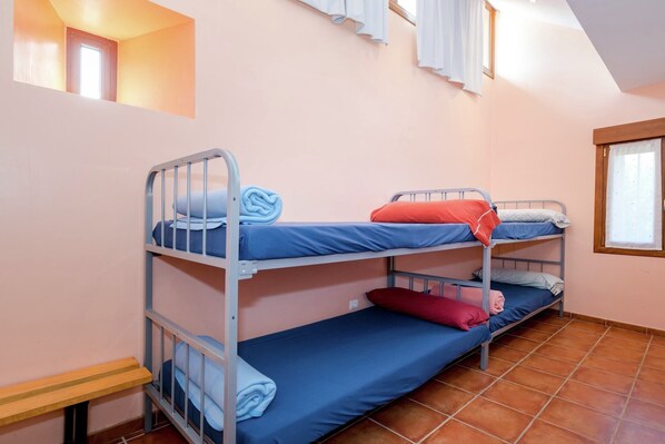 A dormitory room with bunk beds, a small window, and a bench. - Spacious Wine Cellar Mansion (Salinillas de Buradón)