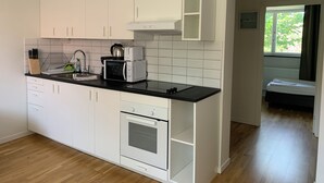 A modern kitchen with white cabinets, a black countertop, and a built-in oven. - Villa Nova (Lund)