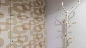 A coat rack with multiple hooks against a wall with a geometric pattern. - Italianway Easy - Plinio 37 (Milan)