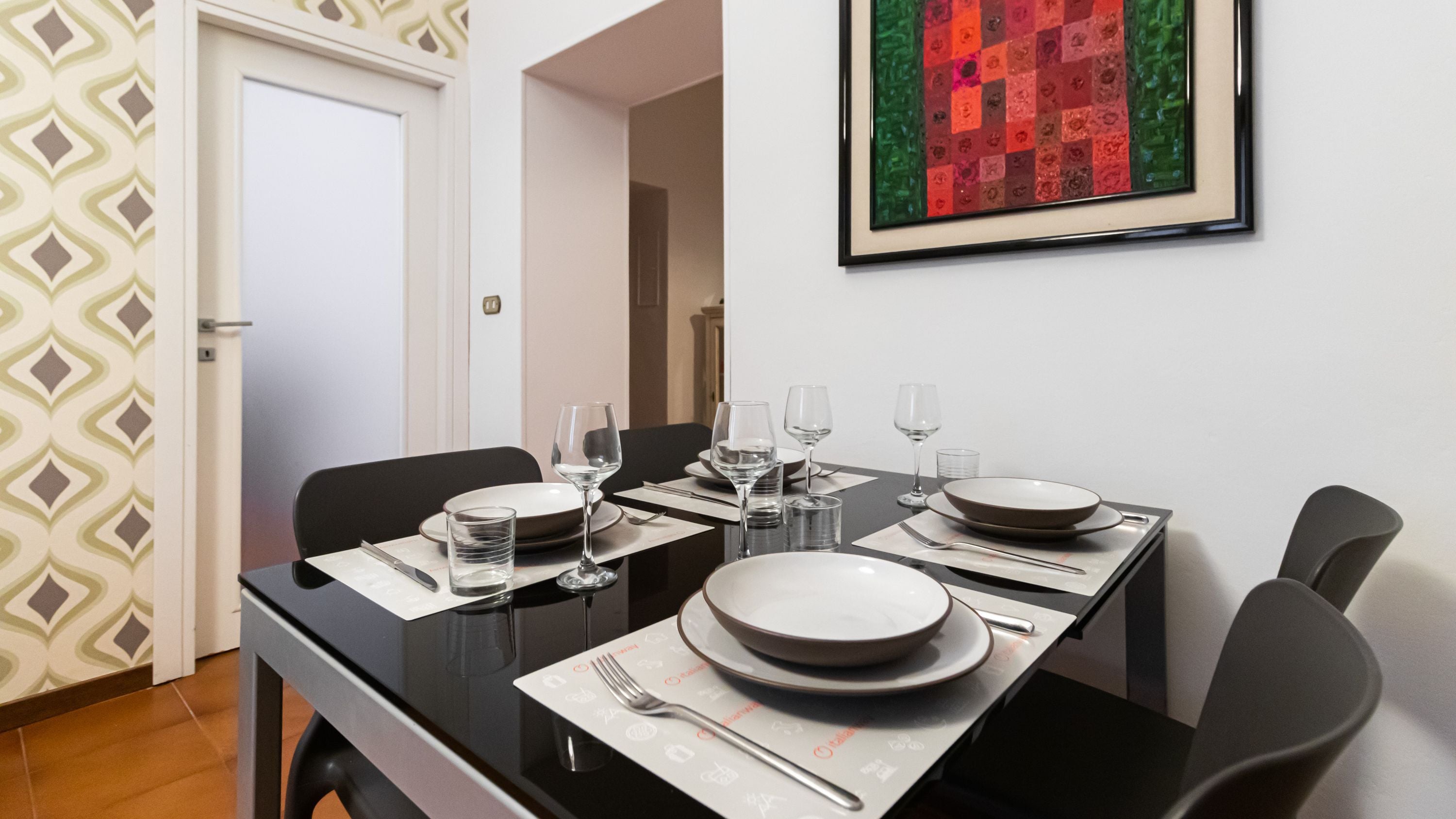 A dining area with a table set for four, including plates, glasses, and cutlery.
