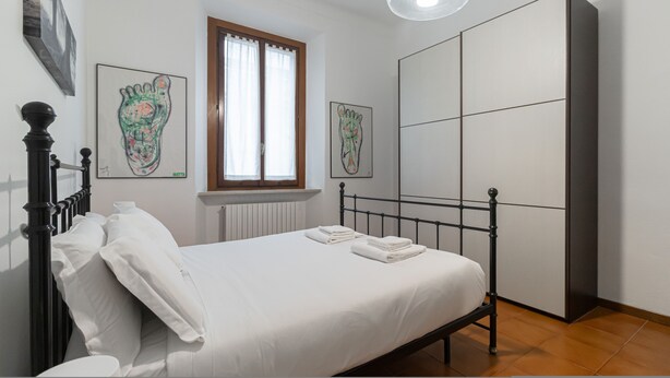 A bedroom with a bed, a window, and artwork on the walls. - Italianway Easy - Plinio 37 (Milan)