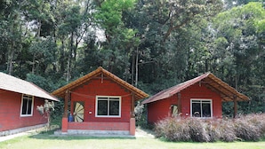 Two red brick houses with pitched roofs, surrounded by lush greenery. - Tusker Valley Resort (Sakleshpur)