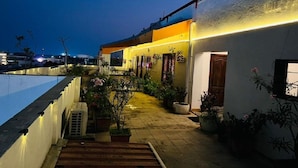 A rooftop terrace with a swimming pool, potted plants, and a staircase leading to the entrance. - The French Villa Elite (Puducherry)