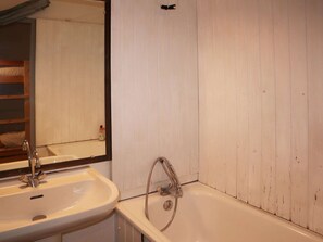 A bathroom with a white sink, a mirror, and a bathtub. - Cozy studio for 6, in the heart of the resort (Les Orres)