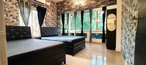 Un dormitorio con cama, cómoda y un ventanal con cortinas.