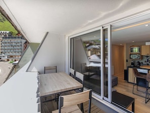 Enjoy a compact living space with a sliding glass door leading to an outdoor area, a kitchenette, and a dining table.