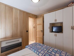 Cozy retreat with a single bed, wardrobe, and TV.