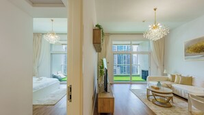 Een ruime woonkamer met een groot raam, een houten salontafel, een bank en een tv-meubel.