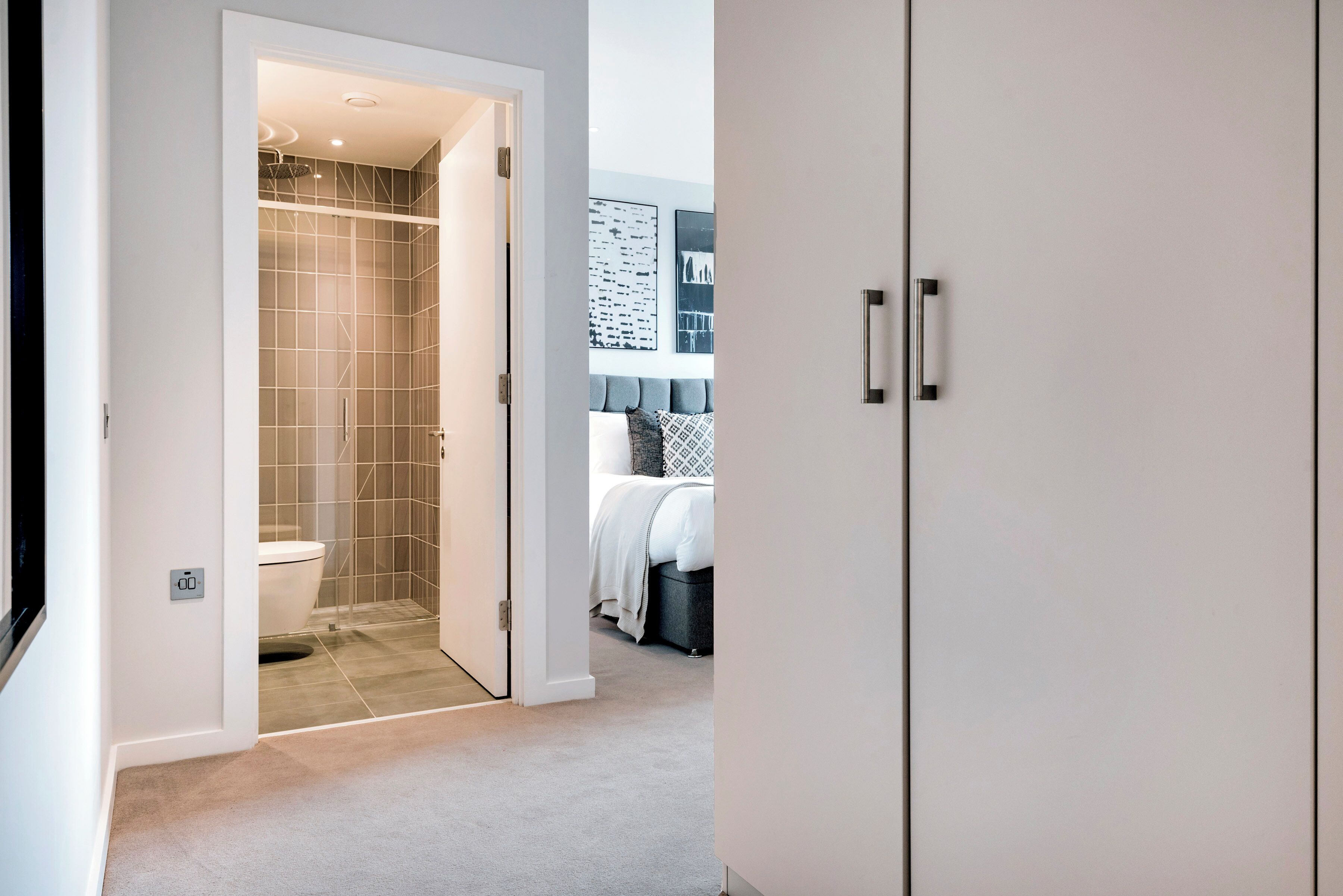 A modern bathroom with a shower, toilet, and a walk-in closet.