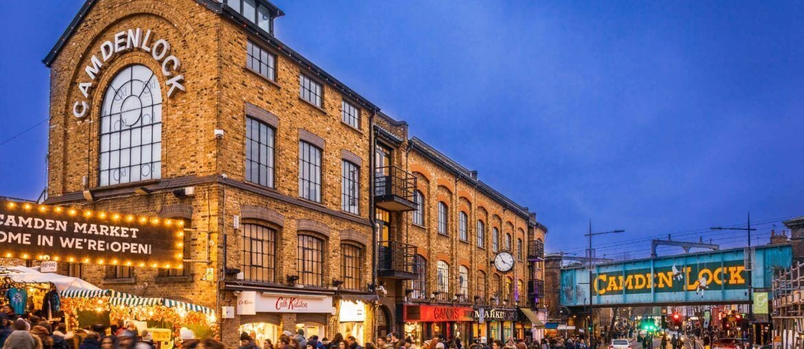 A historic building with a large arched window and signage for Camden Lock Market.