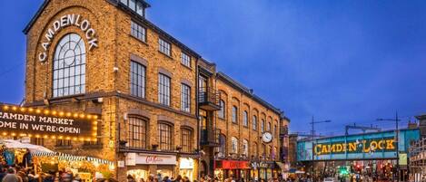 A historic building with a large arched window and signage for Camden Lock Market.
