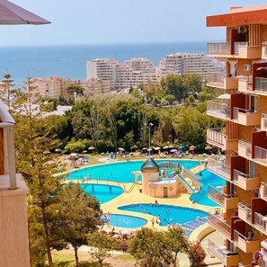 A resort with multiple swimming pools, a central water feature, and a view of the sea. - Studio with sea view - green (Benalmádena)