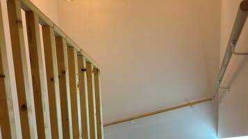 A wooden staircase with a modern light fixture.