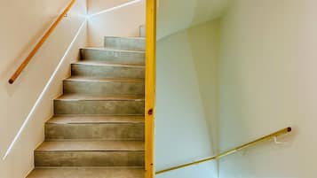 A staircase with a wooden handrail and a glass partition.