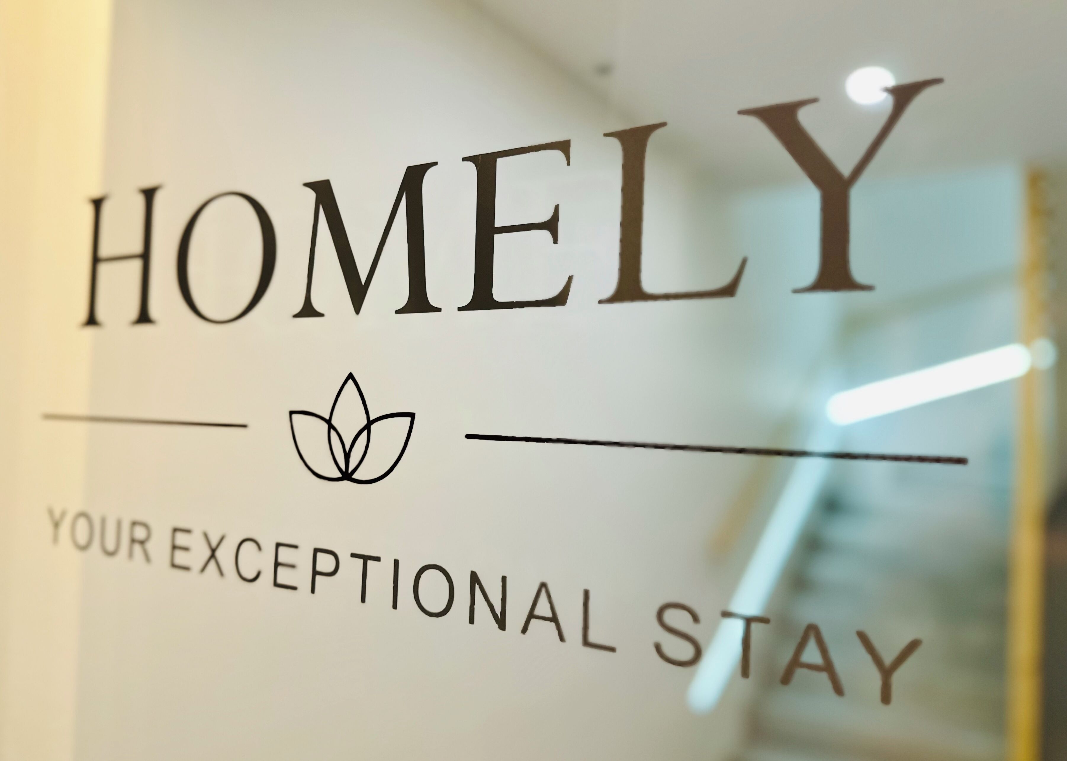 A sign with the word "HOMELY" and a lotus flower symbol, indicating a focus on comfort and relaxation.