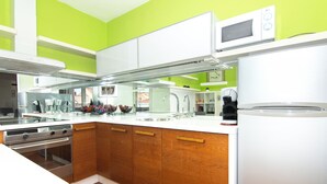 Una cocina moderna con gabinetes blancos, estufa de acero inoxidable y microondas integrado.