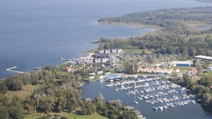 An aerial view of a coastal marina with numerous boats docked, surrounded by residential buildings and lush greenery. - exklusives Appartement in Rechlin (Rechlin)