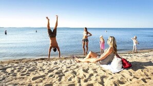 A beach scene with people relaxing and engaging in activities. - exklusives Appartement in Rechlin (Rechlin)