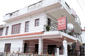 A multi-story building with a sign for Elk Hill Palace Deluxe Home Stay.