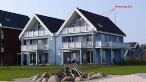 Un immeuble de deux étages doté d’un balcon à l’étage supérieur, portant l’inscription « Wohnung 403 ».