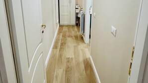 A narrow hallway with wooden flooring and white walls. - Segesta Rooms  (Rome)