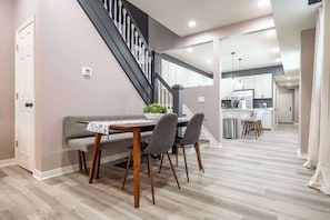 Un espace repas comprenant une table, des chaises et un escalier.