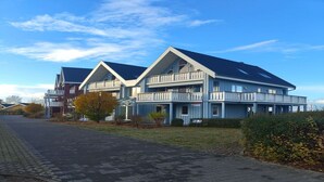 En modern byggnad i två våningar med ett platt tak och balkonger.