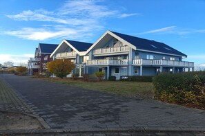 Un bâtiment moderne à deux étages, doté d’un toit plat et de balcons.