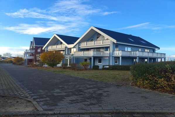 A modern two-story building with a flat roof and balconies. - exklusives Appartement in Rechlin (Rechlin)