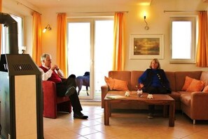 A living room with a piano, a sofa, and a coffee table. - exklusives Appartement in Rechlin (Rechlin)