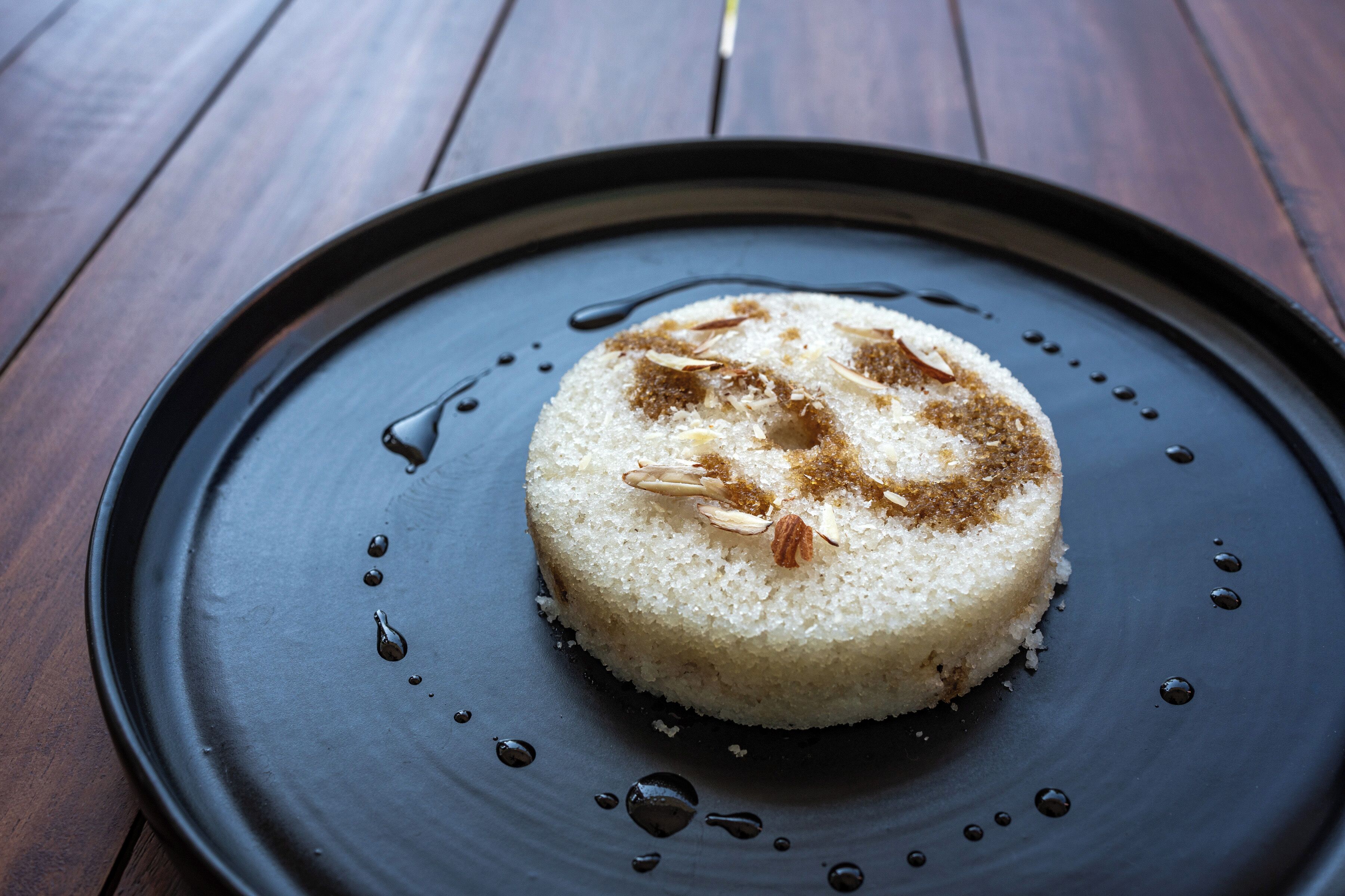 A dessert on a dark plate with a wooden table background.