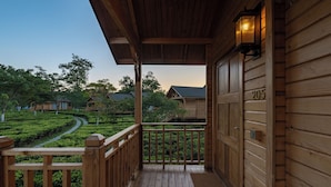 Un portico in legno con vista su un giardino curato e altri edifici.