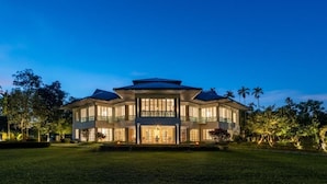 Un'ampia casa moderna dal design simmetrico, con un ingresso centrale e numerosi balconi.