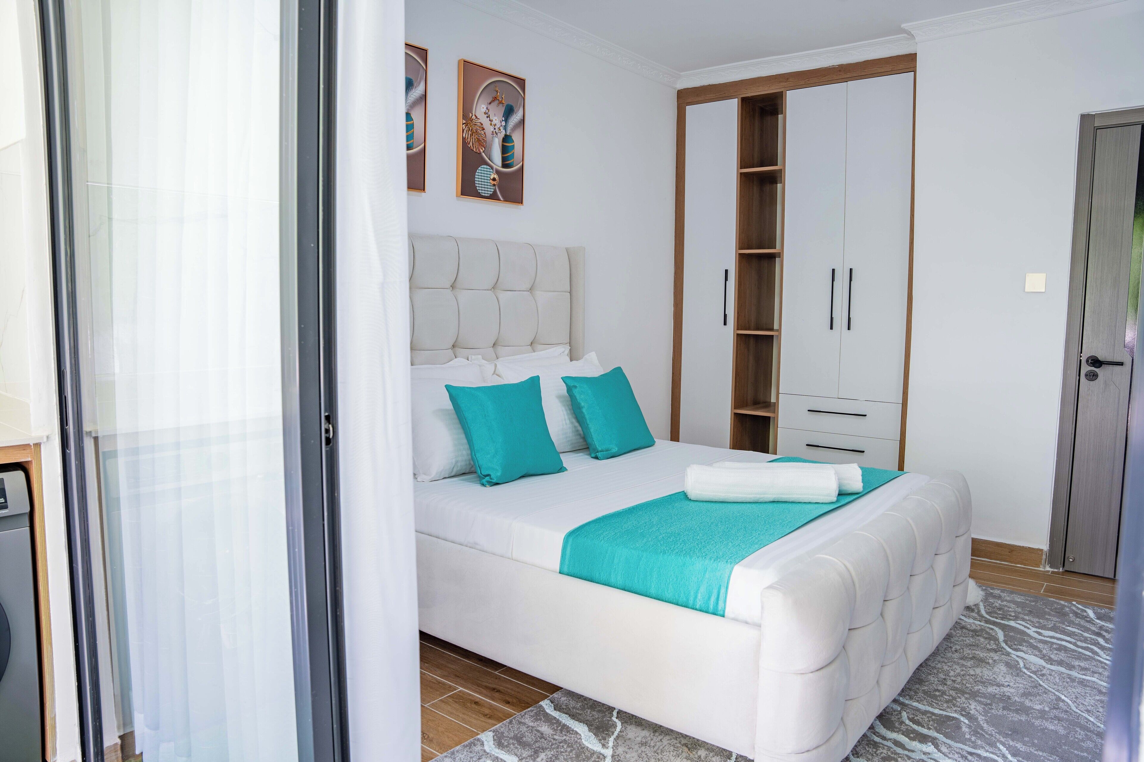 A bedroom with a bed, a wardrobe, and a door.