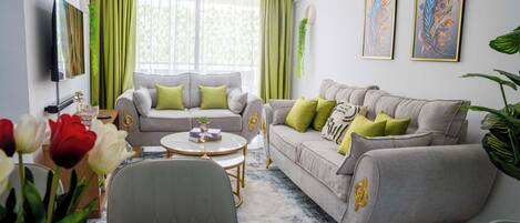 A modern living room with two sofas, a coffee table, and a TV.